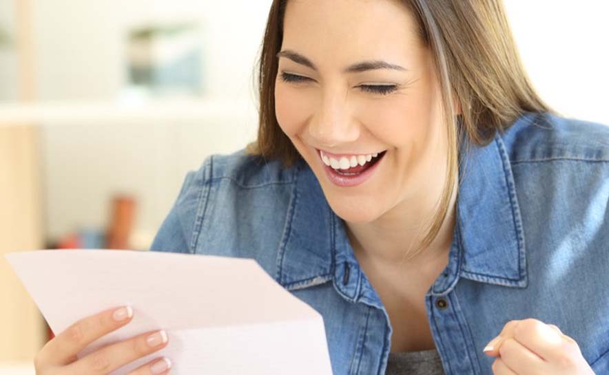 Woman smiling and celebrating reading admissions acceptance letter