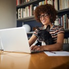 woman on computer with dog in lap