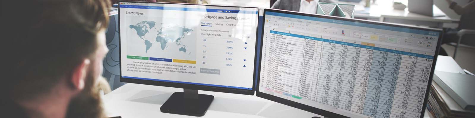 Male accountant in front of 2 computer monitors reviewing spreadsheet data