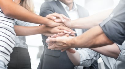 Group of people with hands on each other's hands in support-alt-text