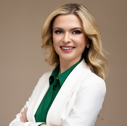 Vita Rymaruk headshot in a white lab coat and green blouse