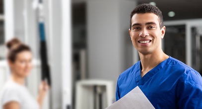 african american male healthcare worker wearing blue scrubs carrying a stack of papers